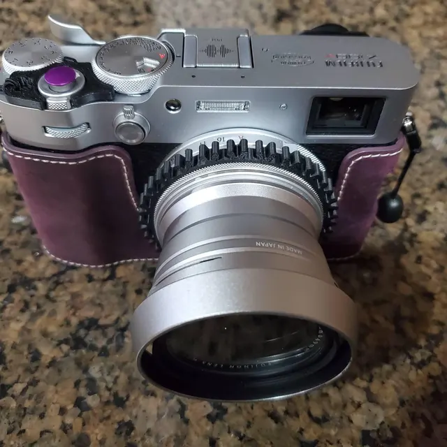 Fujifilm X100VI with black focus ring and purple half-case
